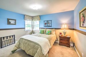a bedroom with blue walls and a bed and a window at Bloomington Family Home - Private Deck and Yard in Bloomington
