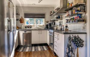 eine Küche mit weißen Schränken und einem Kühlschrank aus Edelstahl in der Unterkunft 5 Bedroom Stunning Home In Mellbystrand in Mellbystrand