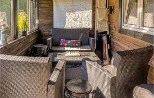 a screened in porch with wicker chairs and a table at 5 Bedroom Stunning Home In Mellbystrand in Mellbystrand