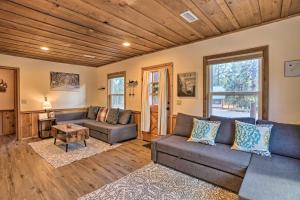a living room with a couch and a table at Peaceful Big Bear Cabin Walk to Lake Access! in Big Bear Lake