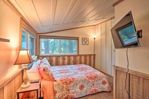 a bedroom with a bed and a tv on a wall at Peaceful Big Bear Cabin Walk to Lake Access! in Big Bear Lake