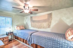 Un dormitorio con dos camas y un ventilador de techo. en Cheery Swansea Home on Calmont Pond with Dock!, en Swansea