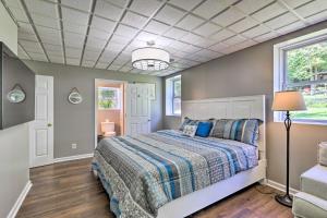 een slaapkamer met een bed met een blauw dekbed bij Charming Georgia Abode with Hot Tub and Grill! in Worthville