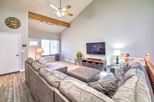 a living room with a large couch and a flat screen tv at Idaho Falls Townhome about 5 Mi to Tauthaus Park! in Idaho Falls