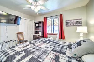 a bedroom with a bed and a window with red curtains at Idaho Falls Townhome about 5 Mi to Tauthaus Park! in Idaho Falls