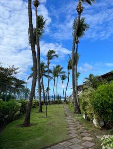 einen Weg mit Palmen am Strand in der Unterkunft Casa beira mar cond fechado farol Itapuã in Salvador