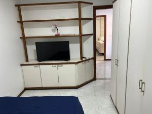 a room with a tv on a shelf at Casa beira mar cond fechado farol Itapuã in Salvador