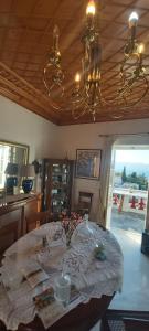 ein Esszimmer mit einem Tisch und einem Kronleuchter in der Unterkunft Tsitsinakis Traditional House in Hydra
