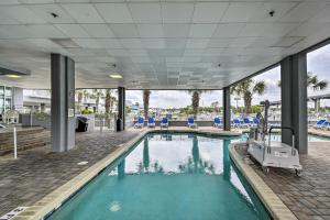 - une piscine avec des chaises bleues dans un bâtiment dans l'établissement Harbourgate Resort Waterfront Condo with Pool!, à Myrtle Beach