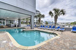 une piscine avec des chaises bleues et un bâtiment dans l'établissement Harbourgate Resort Waterfront Condo with Pool!, à Myrtle Beach