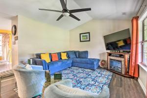 a living room with a blue couch and a flat screen tv at Peaceful Beaufort Home with Front Porch and Grill in Beaufort