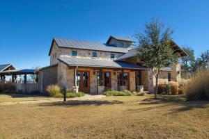 una gran casa de piedra con techo de gambrel en Lake Travis Condo with Resort Amenity Access!, en Jonestown