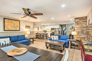 a living room with blue couches and a ceiling fan at Main St Red River Ski Condo with Mountain View! in Red River