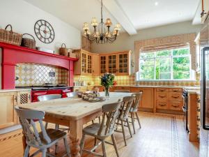 a kitchen with a wooden table and chairs at Hilltop House in Tenbury