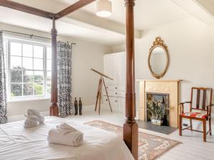 a bedroom with a canopy bed and a fireplace at Hilltop House in Tenbury