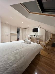 1 dormitorio con 1 cama blanca grande y 1 silla en 93 West Road en Stratford