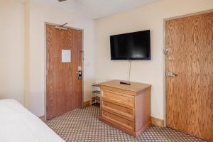 a bedroom with a bed and a dresser with a television on the wall at Grand Lodge 369 in Crested Butte
