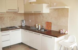 a small kitchen with white cabinets and a sink at Stunning Home In Darlowo With Wifi in Darłowo