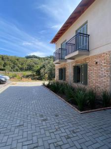 une maison avec une allée en briques devant elle dans l'établissement Pousada Calza - Vale dos Vinhedos - Bento Gonçalves, à Bento Gonçalves