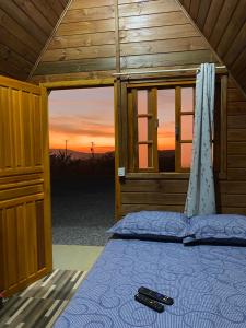 a bed in a room with a view of the sunset at Chalés Carrara in Alto Paraíso de Goiás