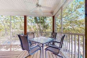Una mesa y sillas en un porche con un ventilador de techo. en Sea Colony - 56053 Pinewood Dr, en Bethany Beach