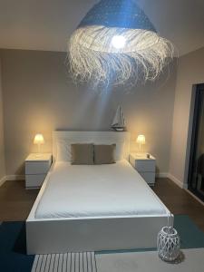 a bedroom with a large bed with a chandelier at AL Florence in Setúbal