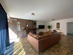 uma sala de estar com um sofá e uma lareira em Maison Clement em Maasmechelen