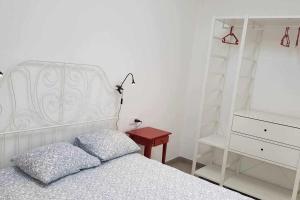 a bedroom with a white bed and a red table at Bungalow n6 en el Camino del Faro in Carnota