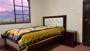 sypialnia z łóżkiem i oknem z widokiem w obiekcie Mateospaxi w mieście Machachi