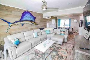 a living room with a couch and a fish mural at Beachfront Retreat! 3 Steps to WALKOVER! in Surfside Beach