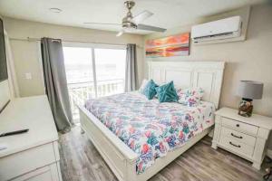 a bedroom with a bed with a dresser and a window at Beachfront Retreat FREE use of GOLF CART in Surfside Beach