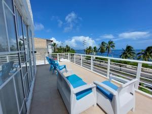 a balcony with two blue and white chairs and the ocean at Bahia San Andres Hospedaje in San Andrés