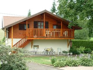 a log home with a deck and a balcony at Gîte Le Val-d'Ajol, 2 pièces, 4 personnes - FR-1-589-194 in Le Val-dʼAjol