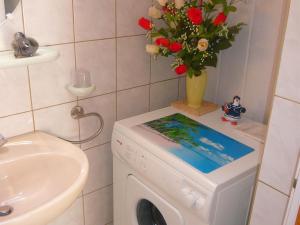 a bathroom with a washing machine with a tablet on it at Gîte Le Val-d'Ajol, 2 pièces, 2 personnes - FR-1-589-172 in Le Val-dʼAjol