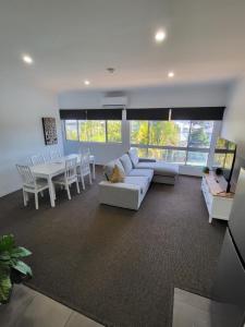 a living room with a white couch and a table at Central Motel Mooloolaba in Mooloolaba