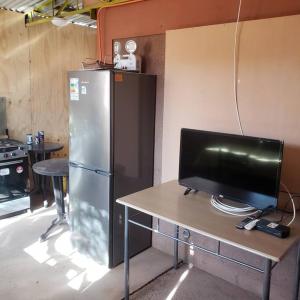a television on a table in a kitchen with a refrigerator at CASA VICTORIA in San Pedro de Atacama