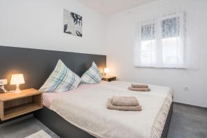 1 dormitorio con 1 cama con 2 toallas en Apartments with a parking space Vir - 20013, en Vir