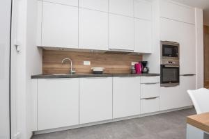 una cocina con armarios blancos y fregadero en Apartments with a parking space Vir - 20013, en Vir