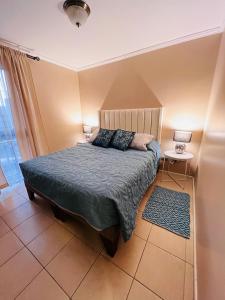 a bedroom with a bed with two lamps on it at Apart Mejillones - Dpto 24 in Mejillones