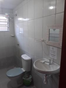 La salle de bains est pourvue de toilettes et d'un lavabo. dans l'établissement Chalés sal da terra/Chalé, à Caraguatatuba