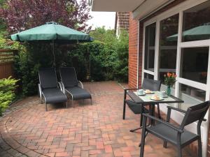 シェーンベルガー・シュトランドにあるOstsee-Entspannung, FeWo direkt am Meerのパティオ(椅子2脚、パラソル付きテーブル付) +9枚の写真