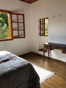 a bedroom with a bed and a table with a mirror at Terrace house in Monte Verde