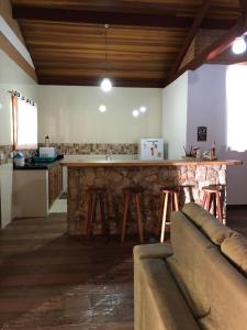 a kitchen with a stone bar with stools at Terrace house in Monte Verde