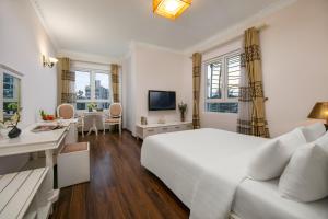 biała sypialnia z łóżkiem, biurkiem i umywalką w obiekcie Nesta Boutique Hotel Hanoi w mieście Hanoi