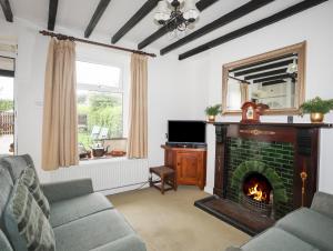a living room with a fireplace and a couch at Pen Dinas in Bangor