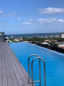 a large blue swimming pool on top of a building at Rooftop infinity pool - St Kilda luxury in Melbourne
