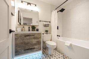 a bathroom with a toilet and a tub and a sink at Designer Cozy Ski in and out in Whistler +27 photos