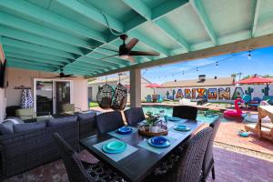 a patio with a table and chairs and a pool at House of Murals with Heated Pool & Huge Game Room in Phoenix