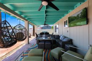 a porch with a couch and chairs and a ceiling at House of Murals with Heated Pool & Huge Game Room in Phoenix