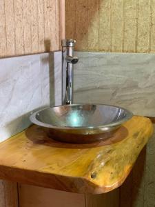 lavabo de metal en una encimera de madera en el baño en Lefun & Lafquen de Pichilemu, en Pichilemu